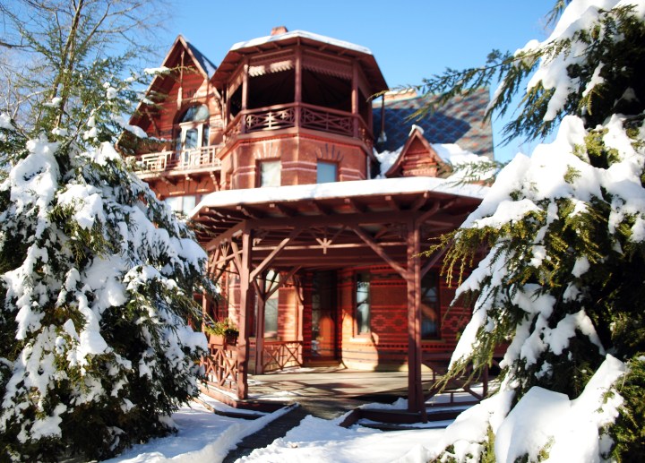 The walkway leading to the porch, flanked by two snowy pine trees.